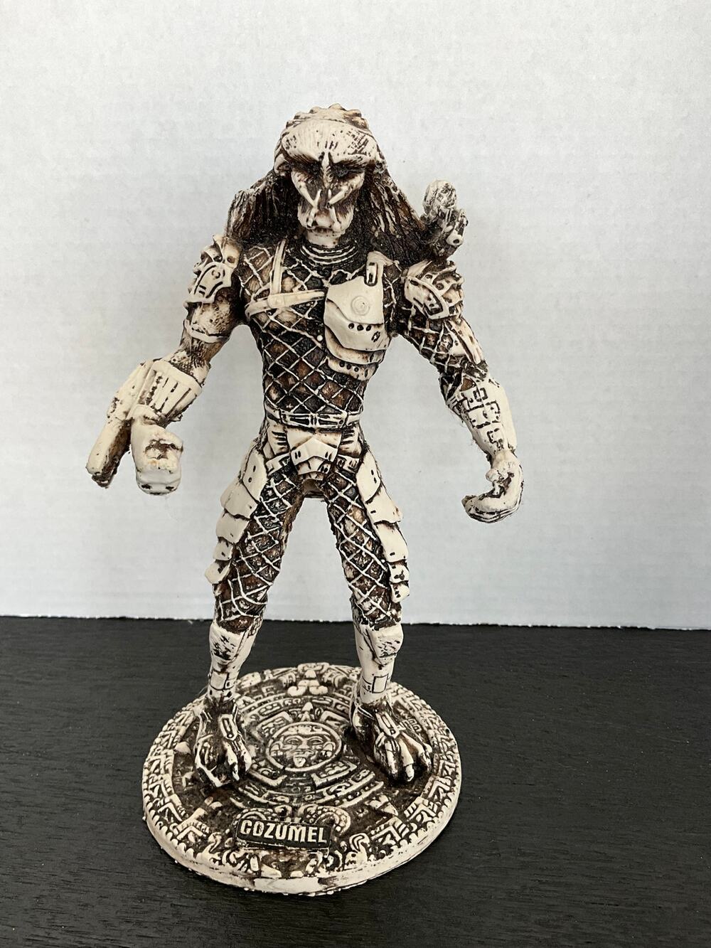 Predator figurine standing on a Mayan/Aztec calendar base